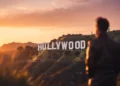 Cinematic sunset over the Hollywood Sign with a film camera silhouette in the foreground, symbolizing Hollywood stories and major celebrity moments
