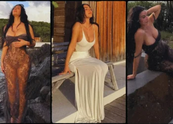 Kim Kardashian poses in a sheer black lace dress on the beach during her latest Instagram photoshoot.