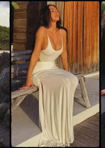Kim Kardashian poses in a sheer black lace dress on the beach during her latest Instagram photoshoot.